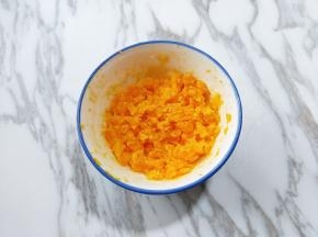 咸蛋黄放入碗中，用勺子将其砸碎。