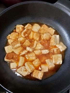 然后倒入豆腐，再加一点点盐和酱油，盖上盖子焖一分钟。