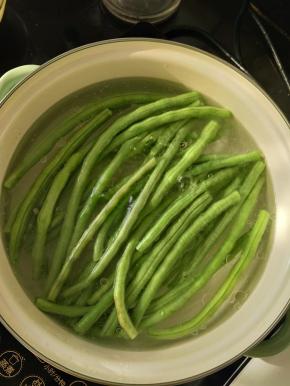 锅里放适量水，加入适量盐和食用油，烧开后放入豆角焯水一分钟左右。