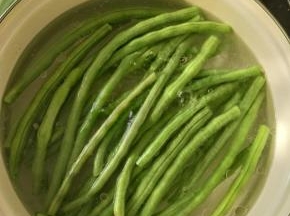 锅里放适量水，加入适量盐和食用油，烧开后放入豆角焯水一分钟左右。