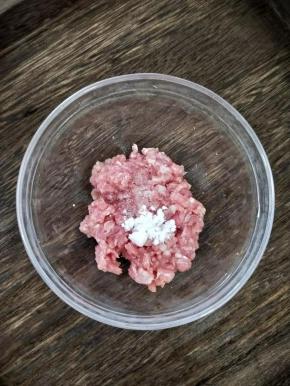 猪肉剁碎后加入适量盐、淀粉和几滴酱油，搅拌均匀后腌15分钟。