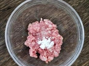 猪肉剁碎后加入适量盐、淀粉和几滴酱油，搅拌均匀后腌15分钟。