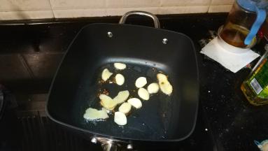 锅里热油、放入花椒、蒜、姜片爆香