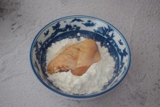 从冰箱取出鸡翅，先把鸡翅放入玉米淀粉中沾上一层薄薄的淀粉