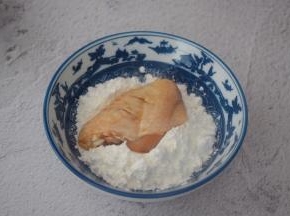 从冰箱取出鸡翅，先把鸡翅放入玉米淀粉中沾上一层薄薄的淀粉