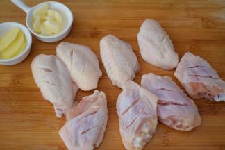 鸡翅洗净用刀在鸡翅正反面各切两刀，方便入味，姜切片，蒜切片备用