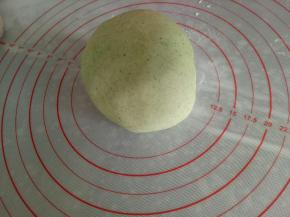 将各颜色的面团摞到一起，用菠菜面团包起来，像平时包包子一样收口，用手掌压一下