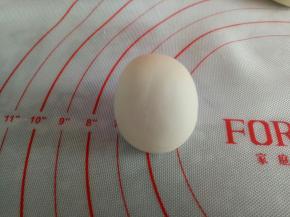 接下来做蛋糕上面的小马，取20克白面团，滚圆收口向下，搓成圆柱状，里面也可以包入你喜欢的馅料