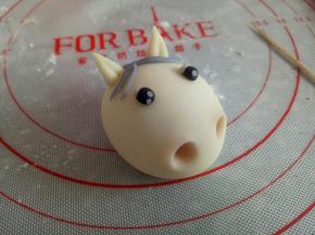 如图所示把小马的耳朵，眼睛做好粘到合适的位置，用筷子把小马的鼻子戳出来，用毛刷刷一点红曲粉