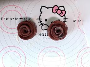 用刮板或者刀把刚才卷好的面片沿中间的压痕切断，一分为二成为两朵玫瑰花，再用手将花瓣都往外掰开一点