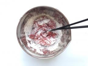 往面粉中加入酵母红曲粉溶液，用筷子搅成絮状，一般需要再用冰水慢慢倒入和面的，我这里加的水有点多了，后来又加了面粉