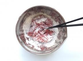 往面粉中加入酵母红曲粉溶液，用筷子搅成絮状，一般需要再用冰水慢慢倒入和面的，我这里加的水有点多了，后来又加了面粉