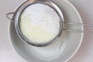 将低筋面粉、奶粉和泡打粉先混合过筛。