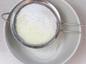 将低筋面粉、奶粉和泡打粉先混合过筛。