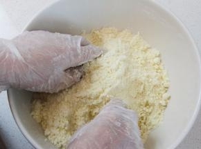 用手将黄油和面粉材料搓成细砂粒状。