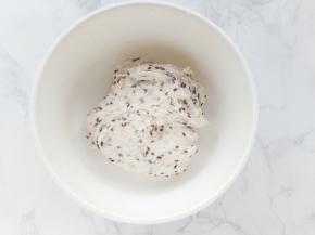 再加入125克水和浸泡好的亚麻籽，用刮刀拌匀。