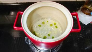 锅里下一碗半水用姜碎和辣椒圈煮开