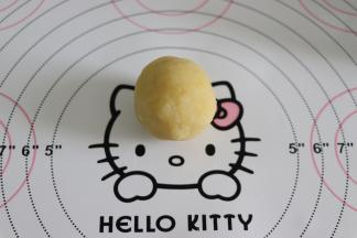 取一个大约40克的绿豆泥，压着搓圆。