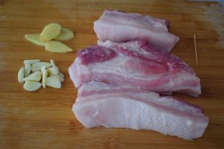 五花肉去皮切成三段，不要切太小，不然不好烤，然后洗净用牙签在五花肉叉些小洞，这样方便入味，蒜切片，姜切片