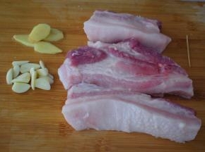 五花肉去皮切成三段，不要切太小，不然不好烤，然后洗净用牙签在五花肉叉些小洞，这样方便入味，蒜切片，姜切片