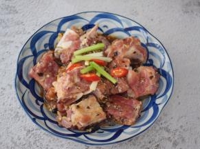 把腌制好的排骨放入盘中，加入葱段和辣椒