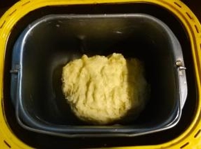 面包桶放回面包机里，按和面功能。结束后再按一次和面功能，这时放入黄油一起搅拌至结束。
