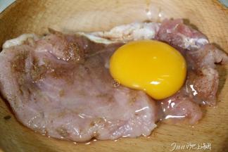 4. 腌制后的猪排冲洗一下，放鸡蛋涂抹均匀。
