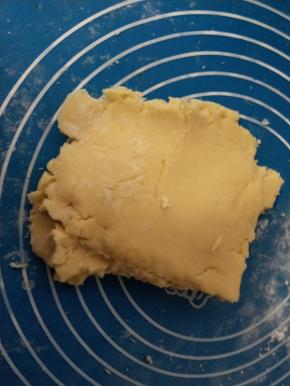 第二次筛入面粉后，面团会比较干，可以把面团倒在面板上，反复揉压均匀。