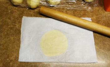 酥皮分成25g一分，放在油纸里，再盖上一层油纸，用手压平压圆
