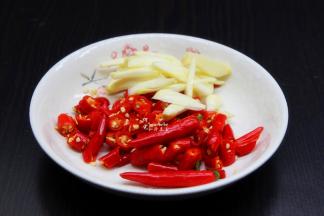 红辣椒洗净、切段，也可以留少许不要切，因为这种辣椒很辣，等会煮熟不要吃，只吃辣椒的味，所以要切长段或不切才不会黏在菜里。生姜、大蒜、香葱等所有食材也洗净切好。