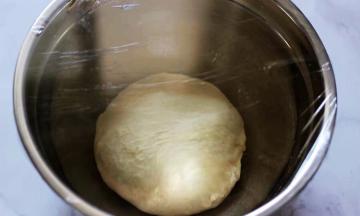 将面团取出，搓圆放入盆内，盖上保鲜膜进行醒发