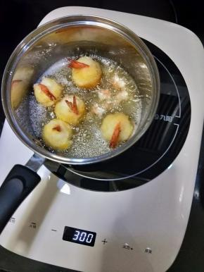 锅里放足够的花生油，五六成热时放入虾球，炸至金黄即可捞出沥油。