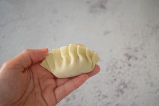 先对折再把上面的饺子皮往左一折一折那样折好捏紧压实