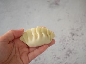 先对折再把上面的饺子皮往左一折一折那样折好捏紧压实