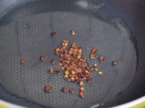 锅中倒入适量的食用油烧热，放入花椒爆香后把花椒捞出不要

