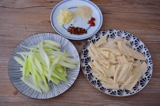 西芹刮去老梗斜切成段，泡发的腐竹也斜切成段，蒜切末，干红辣椒斜成段