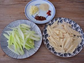 西芹刮去老梗斜切成段，泡发的腐竹也斜切成段，蒜切末，干红辣椒斜成段