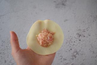 取一张饺子皮，中间放入猪肉金针菇