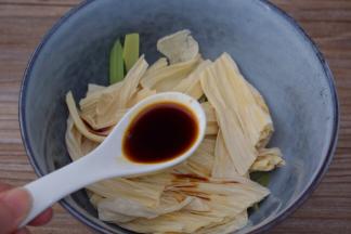 把西芹和腐竹放入容器中，加入味极鲜酱油