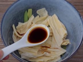 把西芹和腐竹放入容器中，加入味极鲜酱油