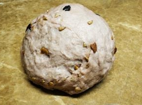 面包桶放回面包机里，倒入红枣瓜子仁，按和面一次。完成一和后，放入黄油再按一次和面功能