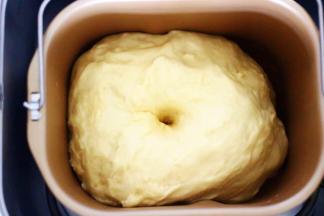 发酵好的面团从面包机取出，盖上保鲜膜排气10分钟