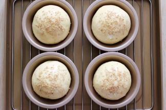 做好的面包胚取出，刷上蛋液，再撒上白芝麻。