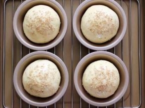 做好的面包胚取出，刷上蛋液，再撒上白芝麻。