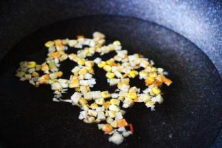 锅中加入清水后，加入玉米粒，胡萝卜丁；
