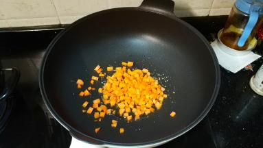 锅里热油放入少许蒜盐，再倒入胡萝卜丁翻炒一会