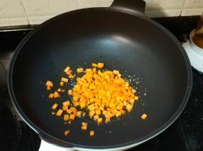 锅里热油放入少许蒜盐，再倒入胡萝卜丁翻炒一会