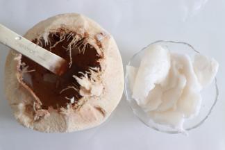 首先来制作椰浆，椰子取汁后，敲开顶部，用勺子或者比较结实的铁片，取出椰肉。