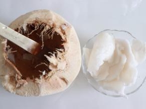 首先来制作椰浆，椰子取汁后，敲开顶部，用勺子或者比较结实的铁片，取出椰肉。