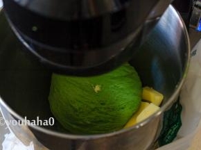 待面团成团变得光滑时，放入室温下已软滑的黄油40克，继续搅打面团。